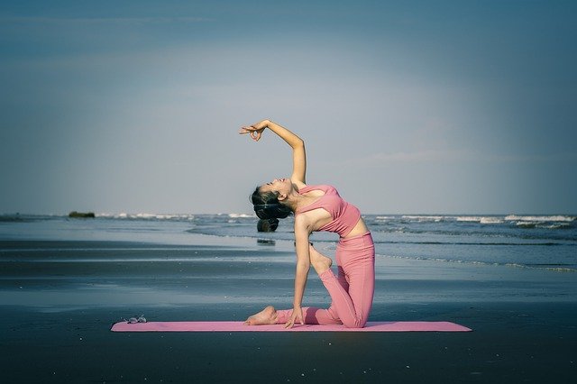 dívka cvičící jógu na pláži